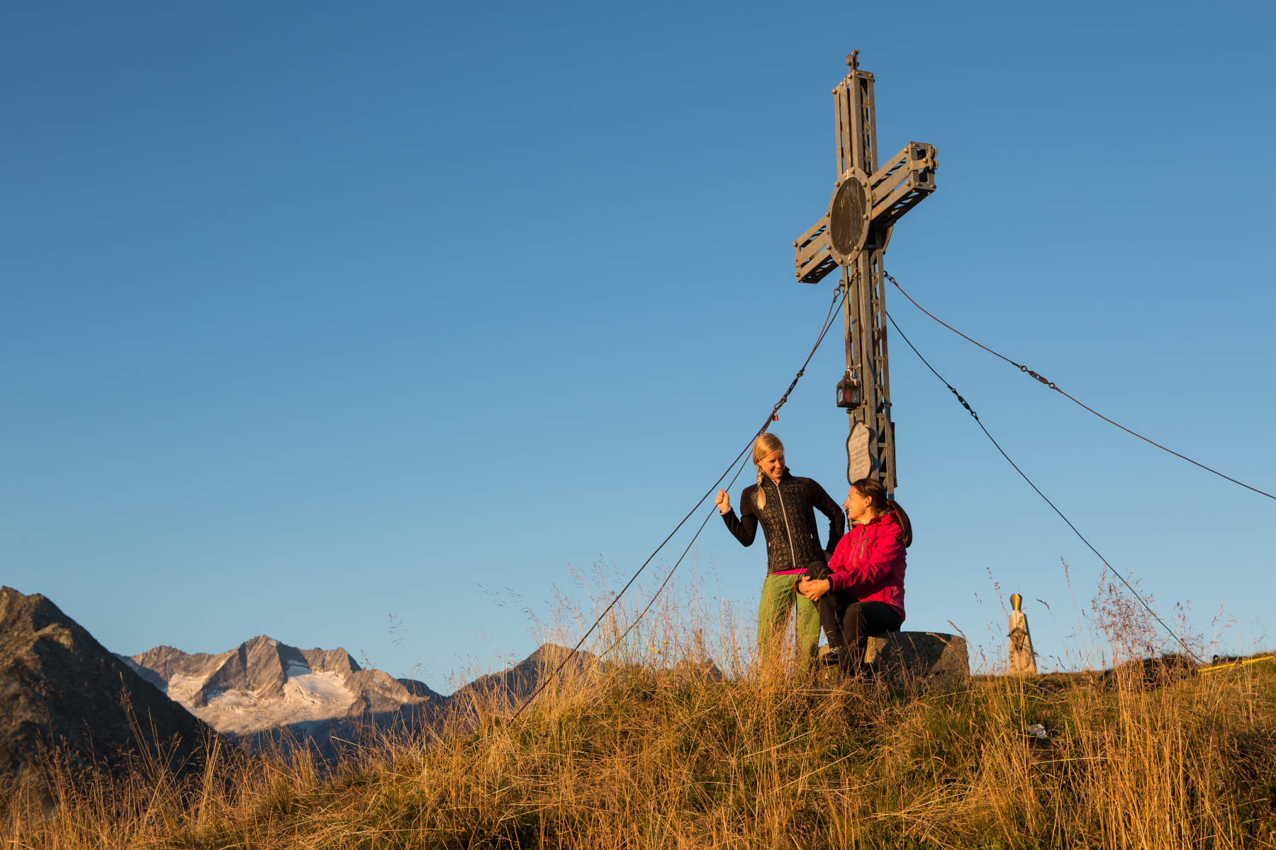 Gipfelkreuz mit 2 Wanderern in der Wildkogelarena