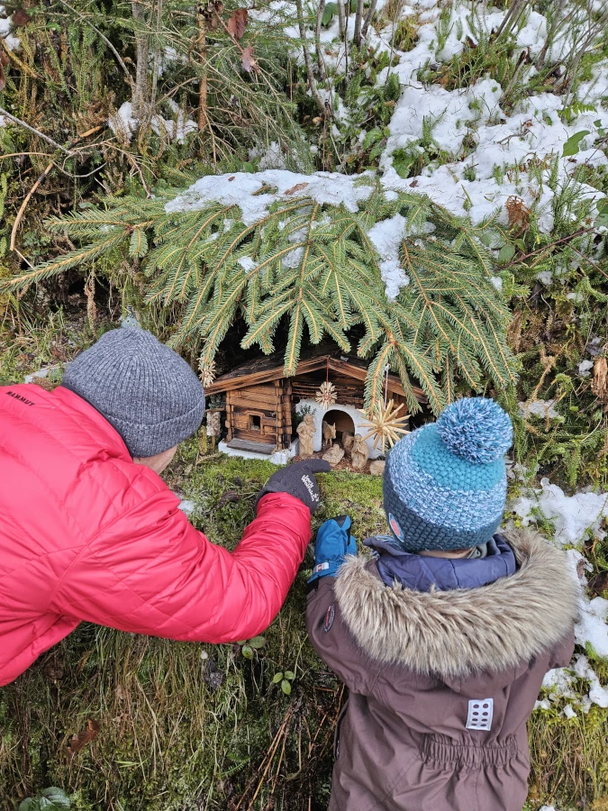 familienspaziergang-advent-krippen Großvater und Enkel bewundern eine Krippe des Walder Krippenwegs im Salzburger Land